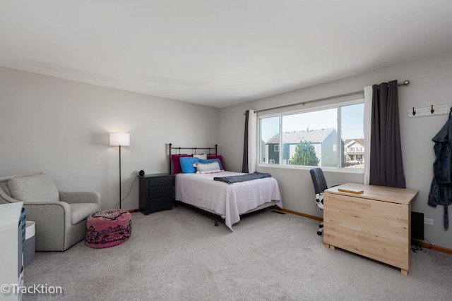 bedroom with light carpet and baseboards