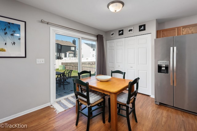 dining room featuring light wood-type flooring and baseboards
