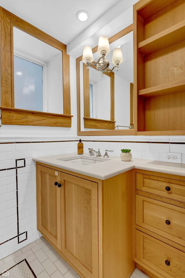 bathroom featuring an inviting chandelier, tile walls, tile patterned flooring, and vanity