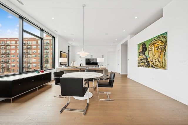 dining room featuring baseboards, light wood finished floors, and recessed lighting
