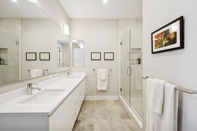 full bathroom with baseboards, a stall shower, and a sink