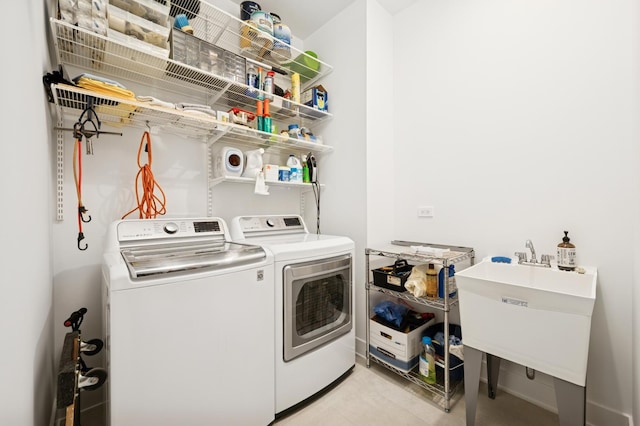 clothes washing area featuring laundry area, washer and dryer, and a sink