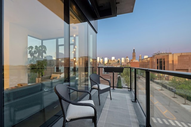 balcony at dusk featuring a city view