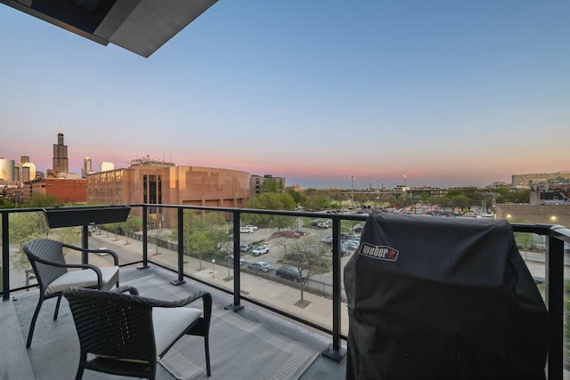 balcony at dusk featuring a grill and a city view