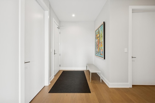 hallway featuring recessed lighting, baseboards, and wood finished floors