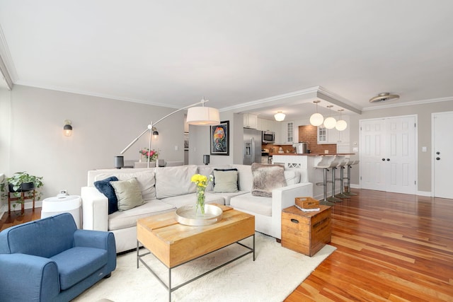 living area featuring ornamental molding and light wood-type flooring