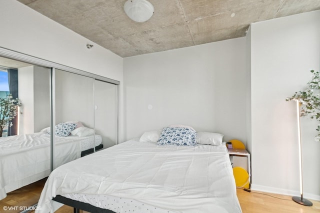 bedroom featuring wood finished floors, a closet, and baseboards