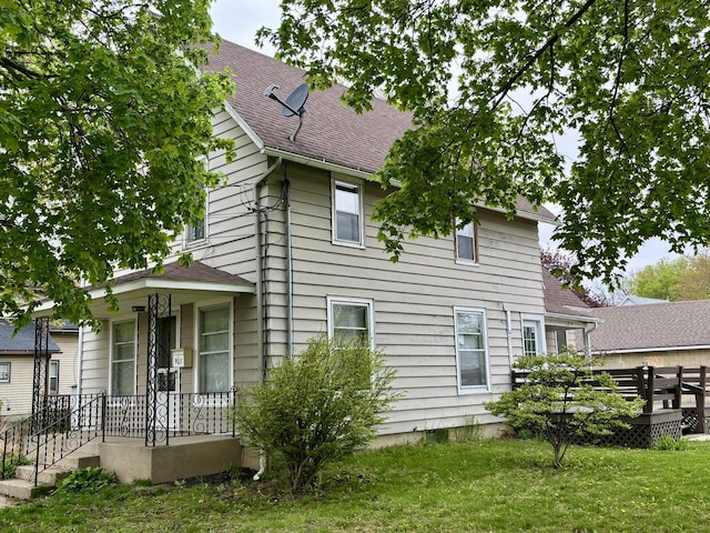 view of home's exterior featuring roof with shingles and a lawn