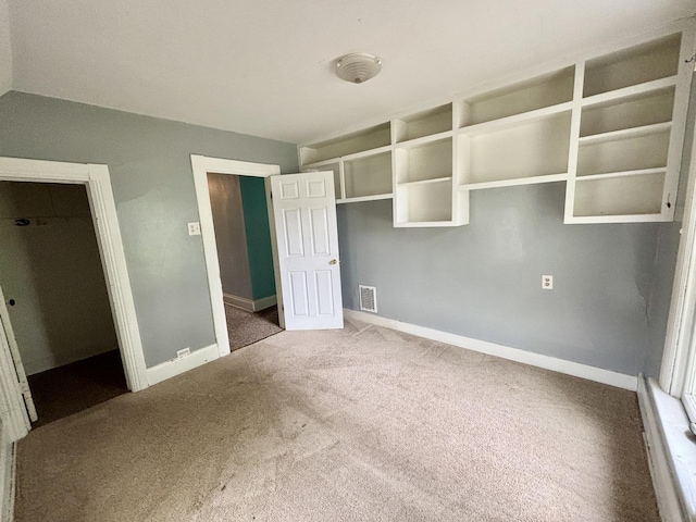 unfurnished bedroom featuring baseboards, carpet flooring, and visible vents