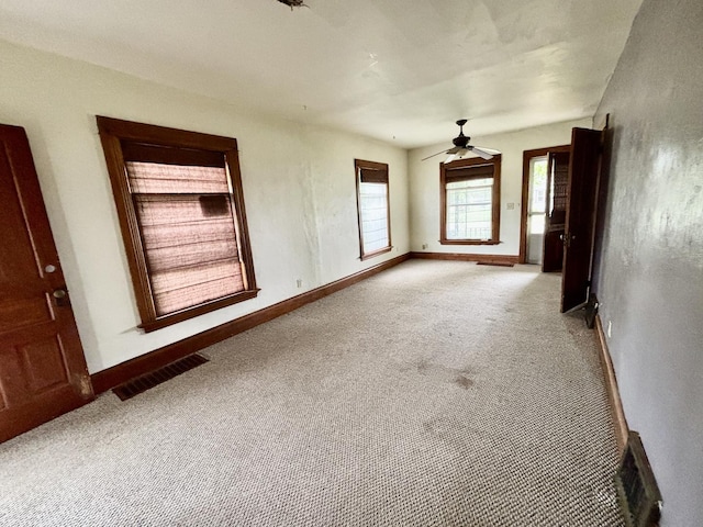 unfurnished room featuring carpet flooring, visible vents, and baseboards