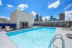 community pool with a patio area and a skyline view