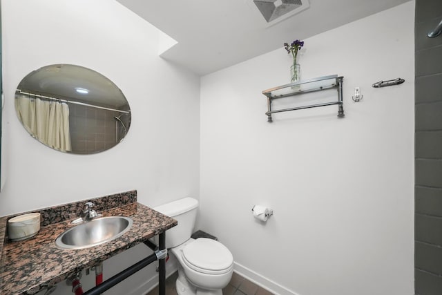 full bathroom with toilet, a shower with shower curtain, tile patterned floors, baseboards, and vanity