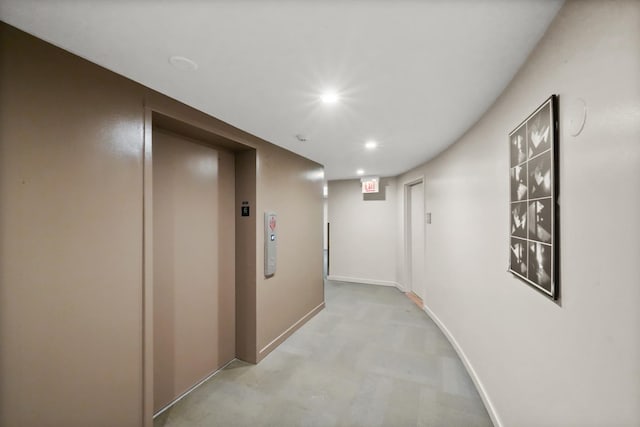 hall with elevator, light carpet, baseboards, and recessed lighting