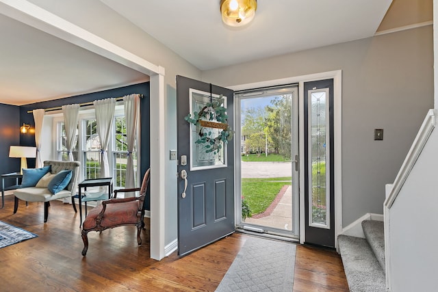 foyer with plenty of natural light, wood finished floors, and baseboards