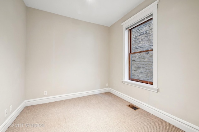 unfurnished room featuring carpet and baseboards