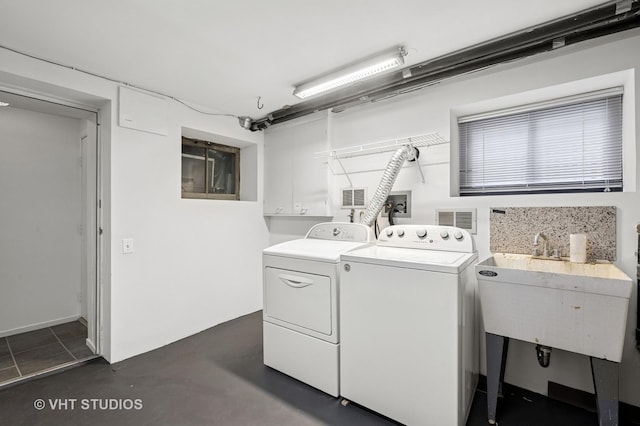 clothes washing area featuring washer and dryer and cabinet space