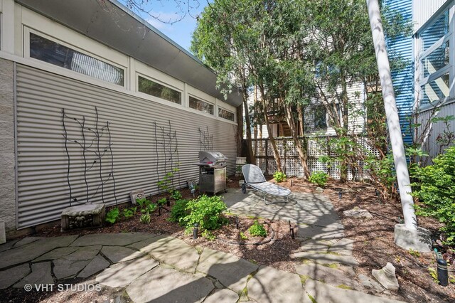 view of patio featuring a grill and fence