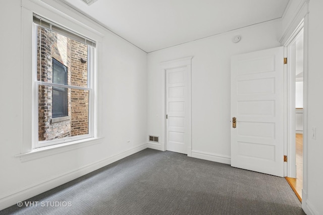 spare room featuring carpet and baseboards