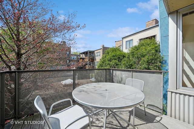 balcony with outdoor dining space and a residential view