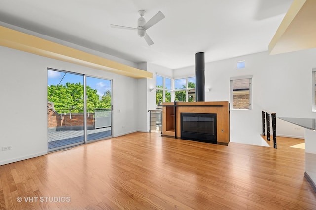 unfurnished living room featuring wood finished floors, a ceiling fan, and baseboards