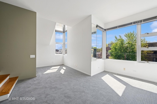 carpeted spare room featuring baseboards
