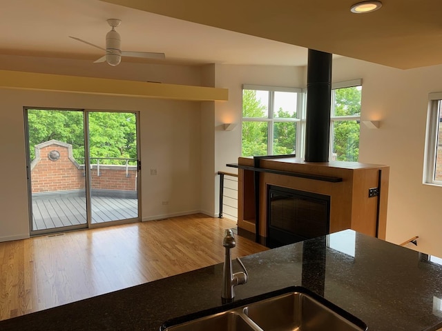 kitchen with healthy amount of natural light, wood finished floors, a ceiling fan, baseboards, and recessed lighting