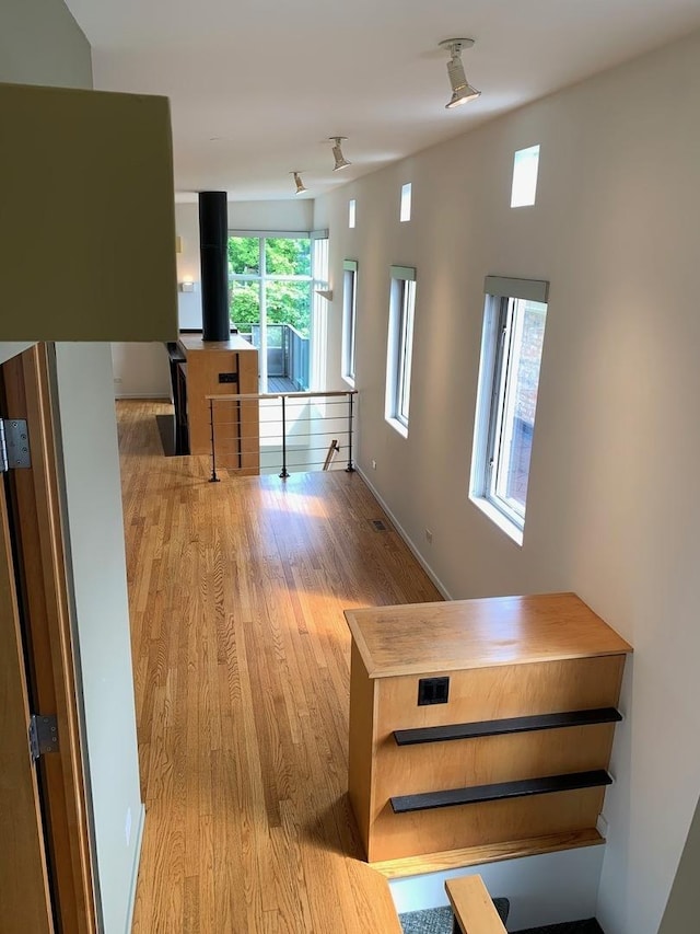 corridor with wood finished floors and baseboards