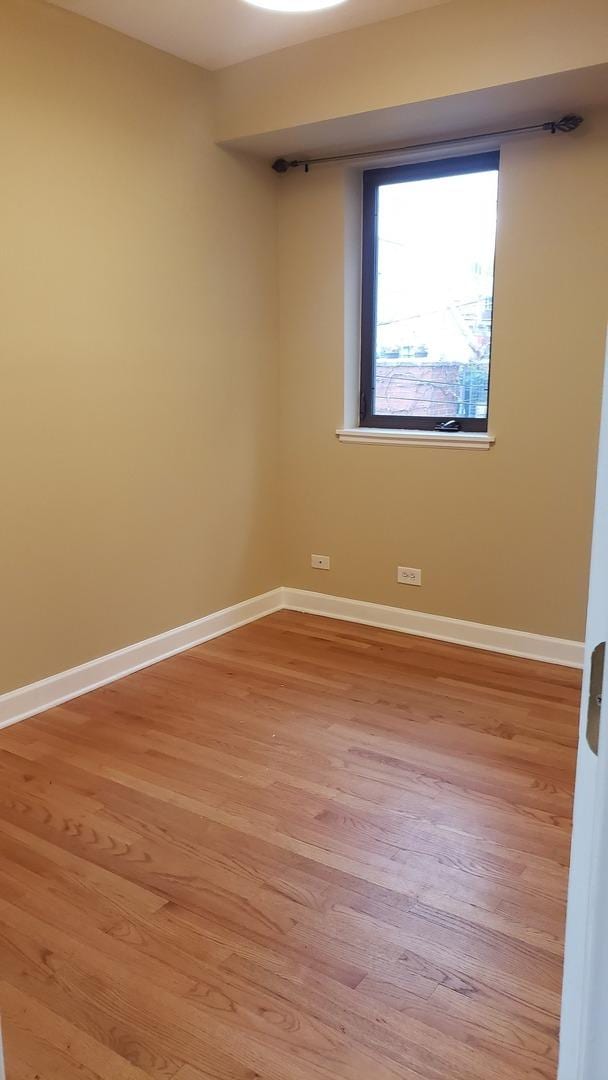 unfurnished room with light wood finished floors and baseboards