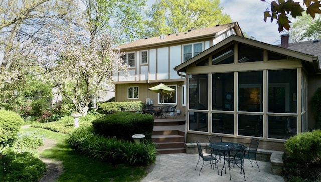 585 Apache Dr, Batavia, IL 60510 - rear view of house with a patio area, a sunroom, and board and batten siding