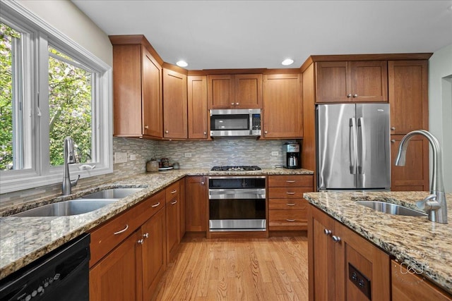 585 Apache Dr, Batavia, IL 60510 - kitchen with stainless steel appliances, a sink, brown cabinets, light wood-style floors, and recessed lighting