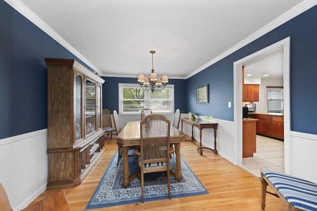 1557 Swallow St, Naperville, IL 60565 - dining area with a chandelier, crown molding, light wood-style flooring, and wainscoting