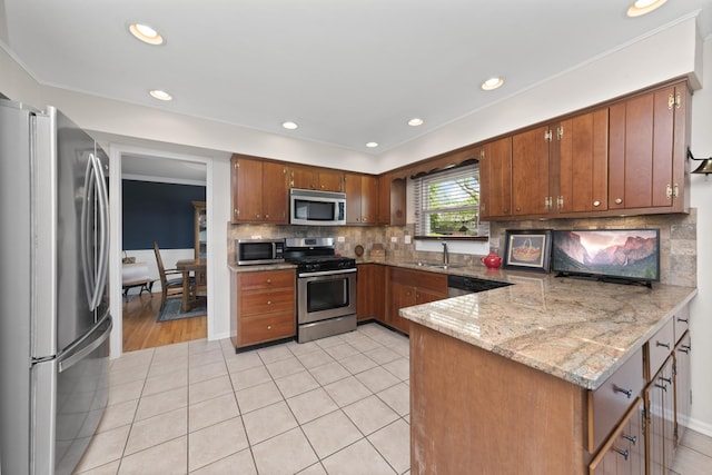 1557 Swallow St, Naperville, IL 60565 - kitchen with appliances with stainless steel finishes, a peninsula, a sink, brown cabinets, and light tile patterned flooring
