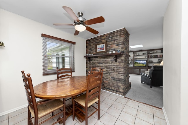 1557 Swallow St, Naperville, IL 60565 - dining area with light tile patterned flooring, ceiling fan, a brick fireplace, and baseboards