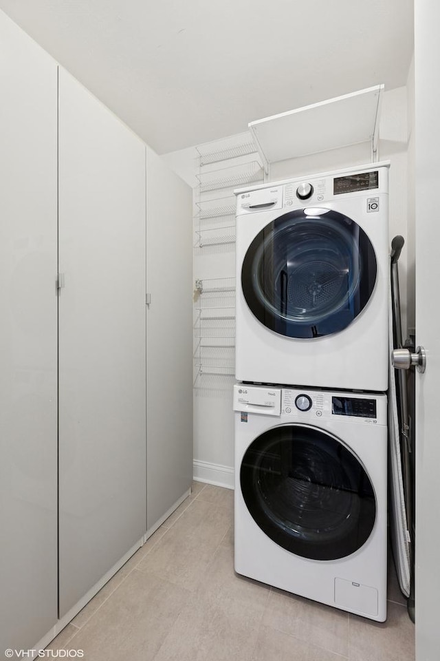 5415 N Sheridan Rd Unit 3004, Chicago, IL 60640 - laundry area featuring stacked washer and clothes dryer, light tile patterned flooring, and baseboards