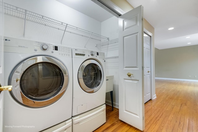 laundry room with washing machine and dryer, light wood-style floors, recessed lighting, and baseboards