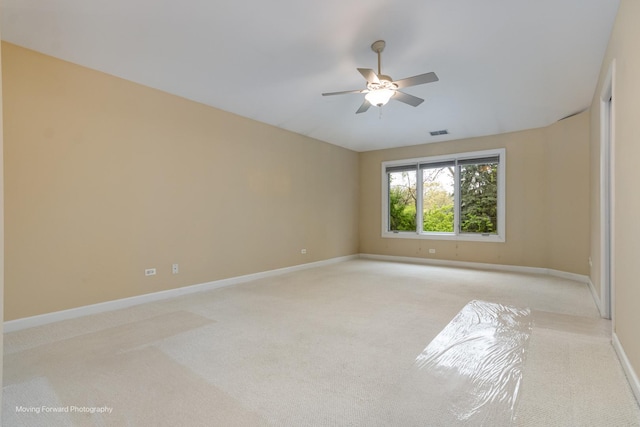 empty room with light carpet, a ceiling fan, and baseboards