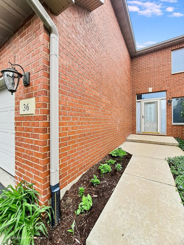 view of exterior entry featuring brick siding