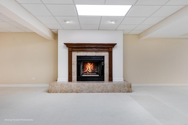 detailed view of carpet floors, a tiled fireplace, baseboards, and a paneled ceiling