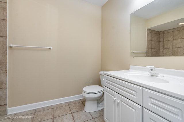 bathroom featuring toilet, vanity, baseboards, and tile patterned flooring