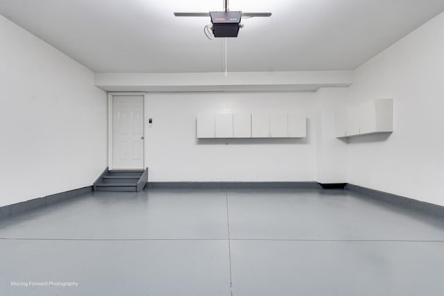 garage with a garage door opener and baseboards