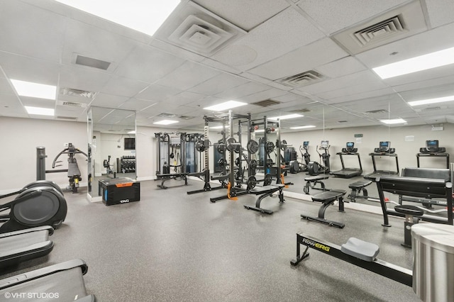 workout area with a paneled ceiling and baseboards