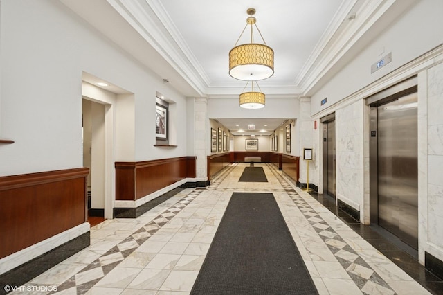 lobby featuring crown molding and wainscoting