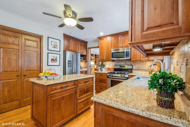 18038 Whitman Ln, Lansing, IL 60438 - kitchen with stainless steel appliances, brown cabinetry, a center island, light stone countertops, and recessed lighting