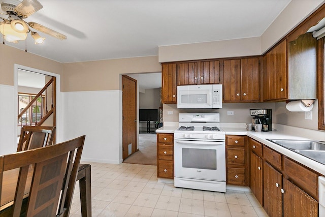 kitchen with white appliances, light countertops, ceiling fan, brown cabinets, and light floors