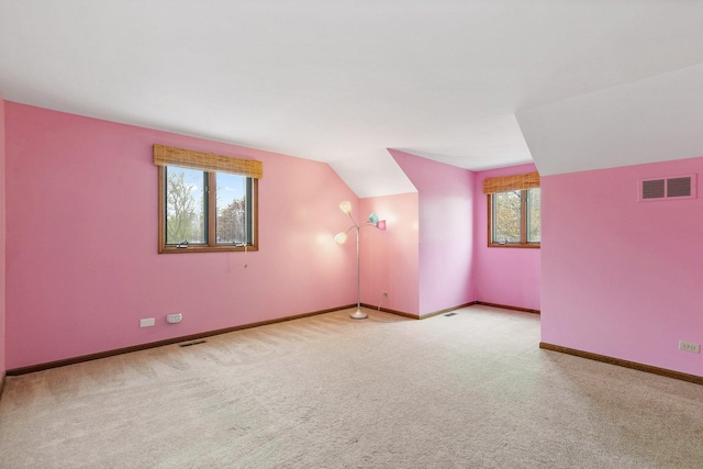 bonus room featuring plenty of natural light, carpet, baseboards, and vaulted ceiling