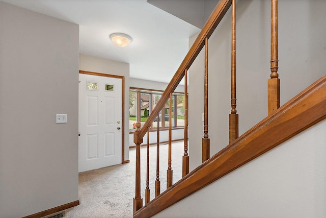 foyer with stairway, carpet, and baseboards
