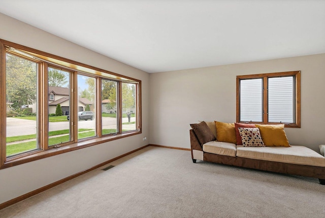 living room featuring baseboards and light colored carpet