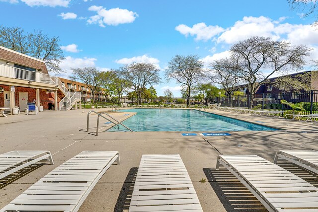 community pool featuring fence and a patio