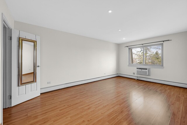 unfurnished room featuring light wood-style floors, recessed lighting, and an AC wall unit