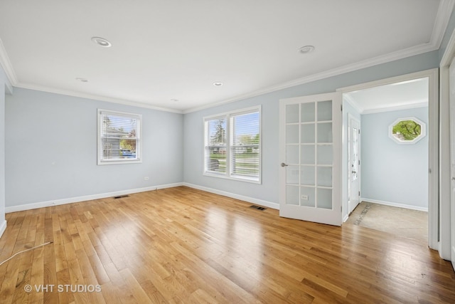unfurnished room featuring light wood finished floors, crown molding, visible vents, and baseboards